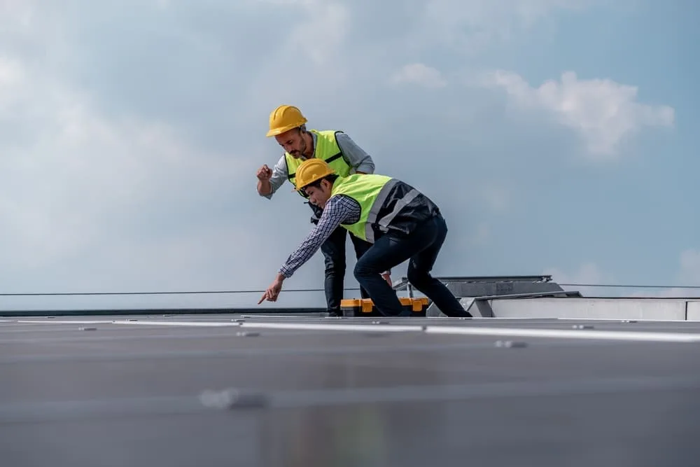 Roofer inspecting roof for damage during the process of commercial roof restoration